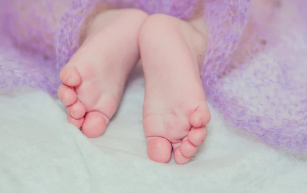 Ноги маленька дитина на ліжку — стокове фото