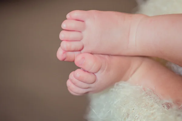 Piernas un pequeño bebé en la cesta — Foto de Stock