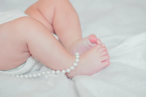 Fötter liten bebis på en säng — Stockfoto