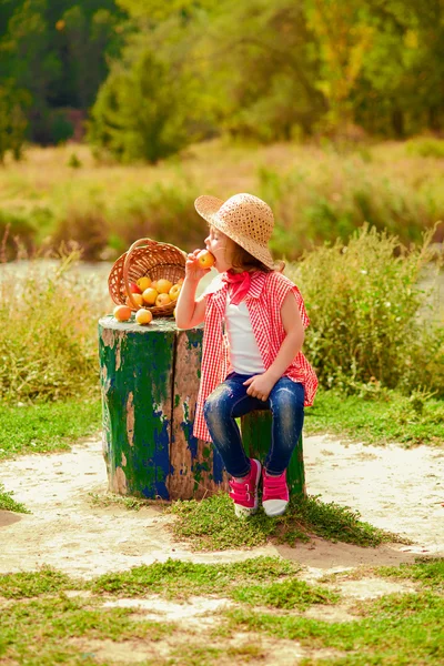 Bambina in jeans e camicia vicino a un fiume in autunno — Foto Stock