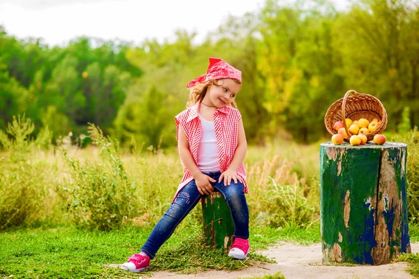 Petite fille en jeans et chemise près d'une rivière en automne — Photo