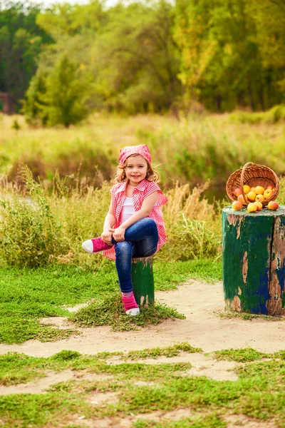 ジーンズや t シャツ秋に川の近くの小さな女の子 — ストック写真