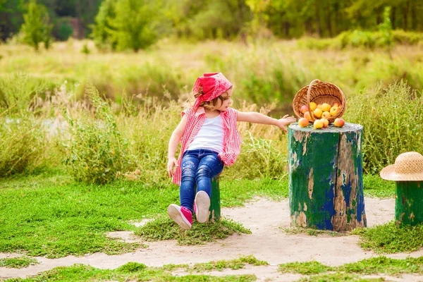 Petite fille en jeans et chemise près d'une rivière en automne — Photo