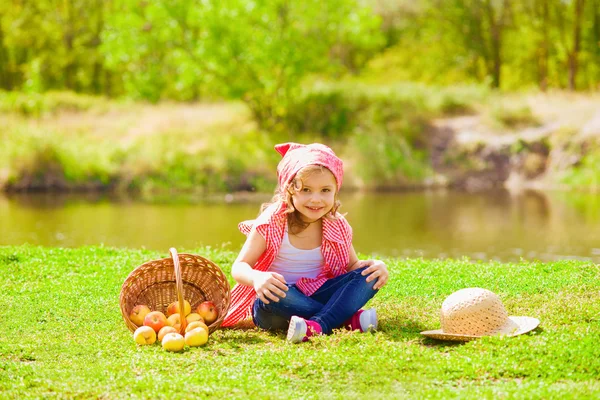 Petite fille en jeans et chemise près d'une rivière en automne — Photo