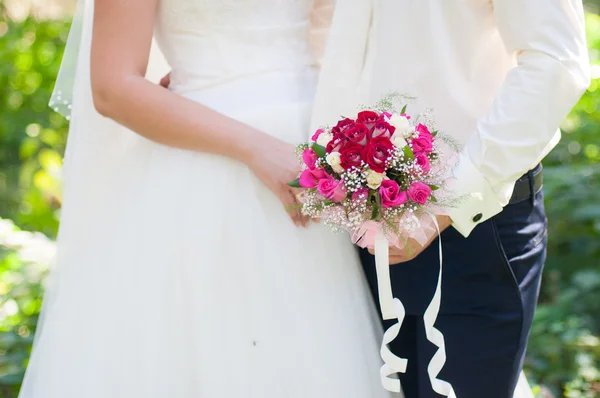 Noiva e noivo com um buquê de casamento de rosas — Fotografia de Stock