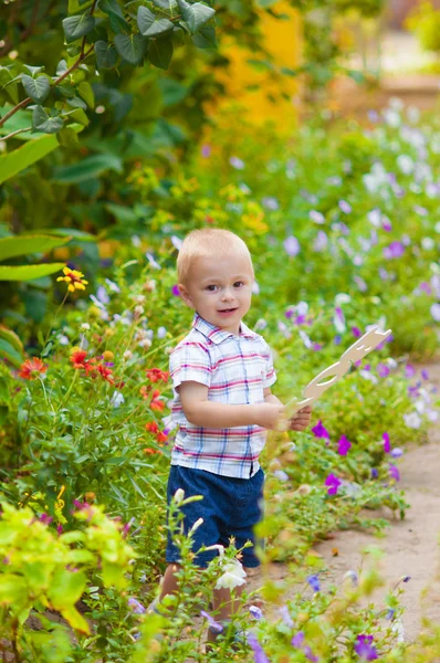 Liten pojke i en lummig trädgård — Stockfoto