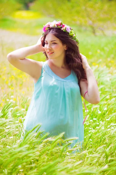 Giovane donna incinta con lunghi capelli ricci in estate — Foto Stock