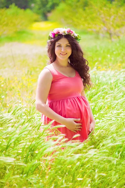 Jeune femme enceinte avec de longs cheveux bouclés — Photo