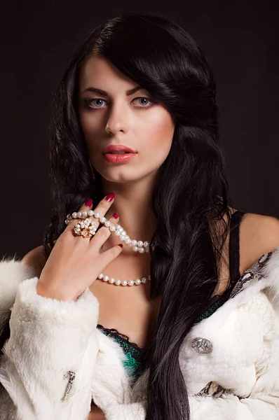 Beautiful girl with dark hair in a white fur coat — Stock Photo, Image