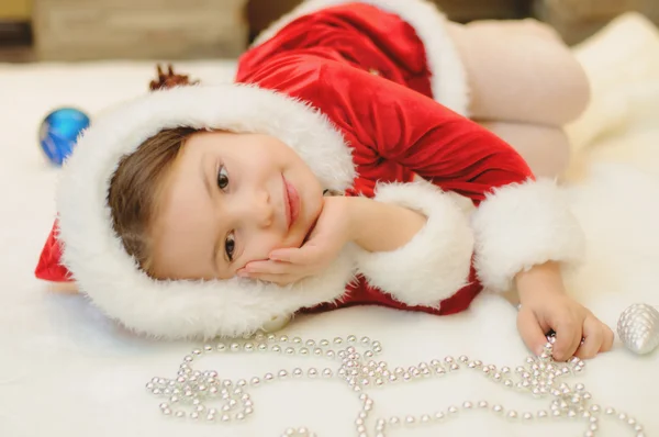 Menina vestida de Santa junto à lareira — Fotografia de Stock