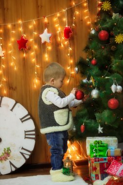 büyük bir saat ve Noel ağacı, hediyeler ile küçük çocuk