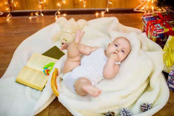 Little baby with gifts at Christmas tree — Stock Photo, Image