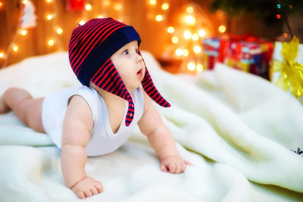 Kleine baby met geschenken bij kerstboom — Stockfoto