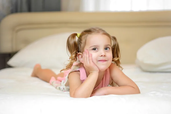 Kleines Mädchen auf dem Bett zu Hause — Stockfoto