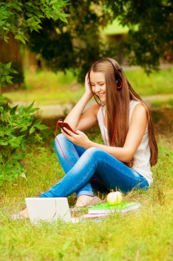 Telefon ve bilgisayar ile kulaklık kız öğrenci