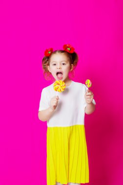 Bir büyük candy lolipop ile güzel elbiseli küçük kız