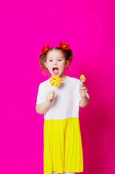 Niña en un hermoso vestido con una gran piruleta de caramelos —  Fotos de Stock