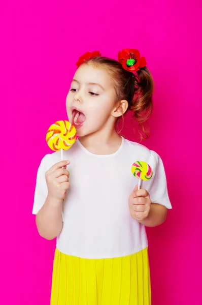 Little girl in a beautiful dress with a big candy lollipop — Stock Photo, Image