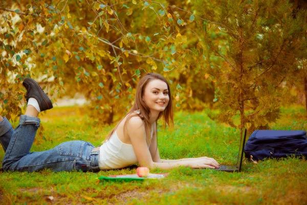 Studente ragazza su erba con un computer — Foto Stock