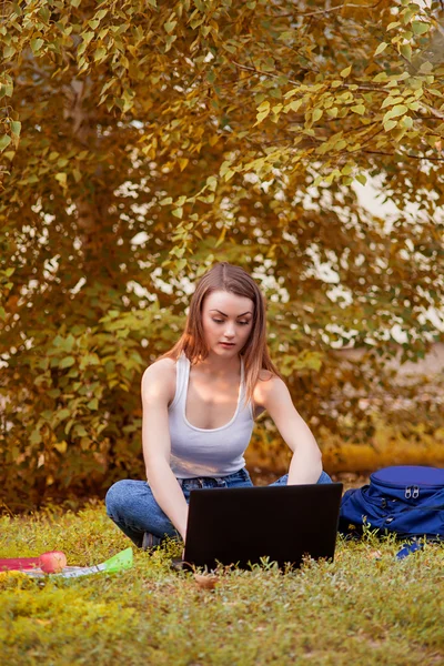 Estudiante chica en la hierba con ordenador — Foto de Stock