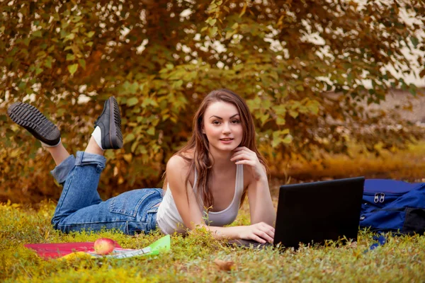 Estudante menina na grama com computador — Fotografia de Stock