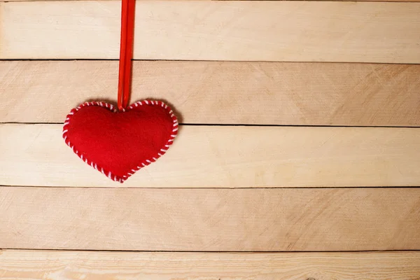 Corazón rojo textil sobre una textura de madera —  Fotos de Stock