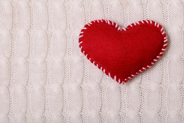 Textilní červené srdce na bílých pletených textury — Stock fotografie