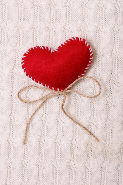 Coração vermelho têxtil em uma textura de malha — Fotografia de Stock