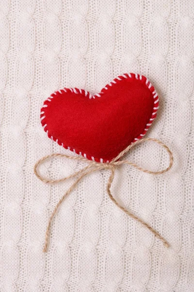 Coração vermelho têxtil em uma textura de malha — Fotografia de Stock