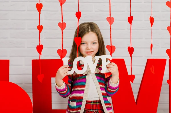 Petite fille au cœur et à la décoration pour la Saint Valentin — Photo