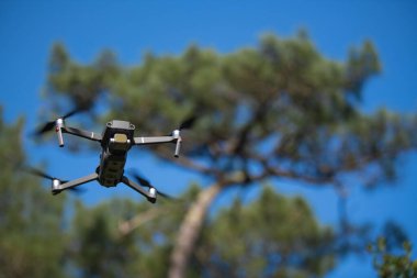 Sabahları açık mavi gökyüzüyle ormanda pilotsuz uçak kullanmak.