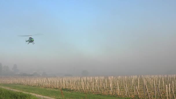 FRANCE, GIRONDE, SAINT-EMILION, HELICOPTER USED TO CIRCULATE WARMER AIR AND AVOID DAMAGE CAUSED BY FREEZING IN THE VINEYARD DURING TEMPERATURES BELOW ZERO ON APRIL 7, 2021 — стокове відео