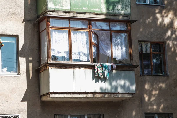 Balkondaki açık pencereden sarkan şeyler kurumaya bırakılmış.