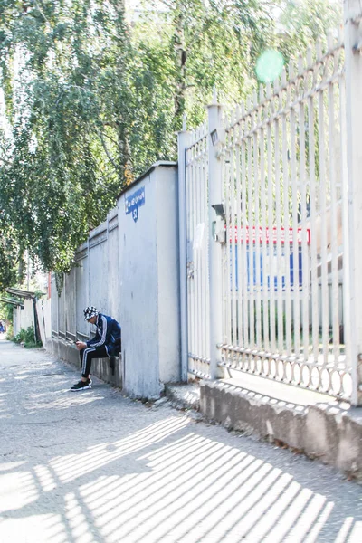 2020年9月23日ロシアのピャチゴルスク Let Oktyabrya AvenueにNcfuの建物の隣のフェンスの近くの縁に座っている若い男 — ストック写真