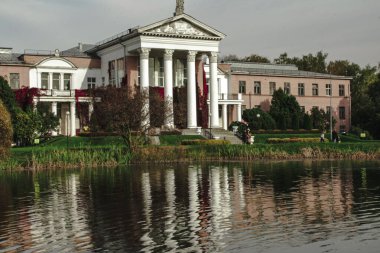 Moskova, Rusya, Ekim 06, 2020: Botanik Bahçesindeki gölette beyaz sütunları ve keskin çatısı olan güzel bir bina