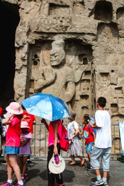 Luoyang, Çin, 3 Ağustos 2018: Uzun adam Budist mağara tapınağı kompleksi, turistler resim çekiyor ve heykelleri ve manzaraları keşfediyorlar