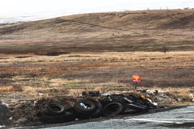 Stavropol Bölgesi, Rusya, 17 Ocak 2021: Eski araba lastikleri otoyolun yanındaki bir arazide yığılmış.