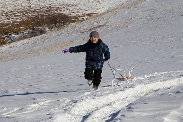 Garçon Vêtements Hiver Traverse Champ Enneigé Tire Traîneau Derrière Lui — Photo