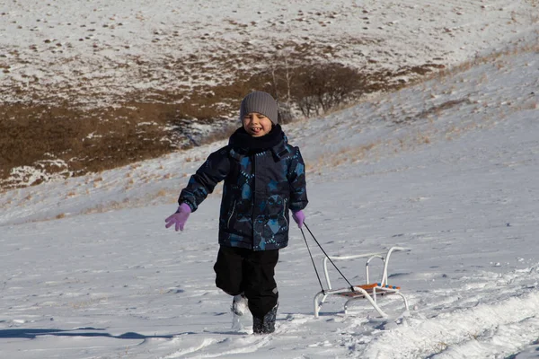 Мальчик Зимней Одежде Бежит Снежному Полю Тянет Собой Сани — стоковое фото