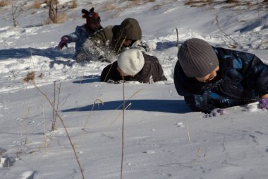 Çocuklar karda oynuyor: karda emekleyin, yakalayın ve kartopu oynayın