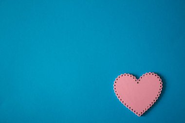 Mavi arka planda, pembe ve kırmızı kalpler, Sevgililer Günü için çizimler yatar. 