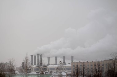 Buhar ve dumanın çıktığı ısıtma tesisinin bacalarının görüntüsü 