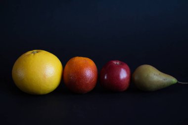 Kırmızı elma, sarı greyfurt, turuncu ve yeşil armut. 