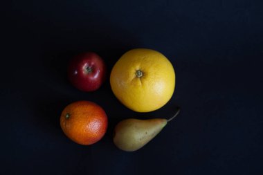 Kırmızı elma, sarı greyfurt, turuncu ve yeşil armut. 