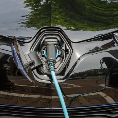 Güç kaynağı takılı modern elektrikli araba şarj ediliyor