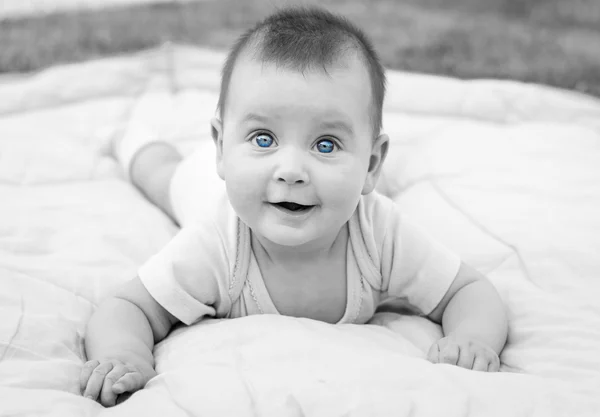 Cute little baby girl is smiling and playing on grass — Stock Photo, Image