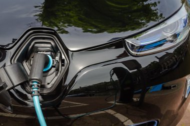 Güç kaynağı takılı modern elektrikli araba şarj ediliyor