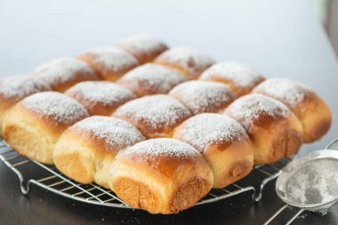 Üstünde pudra şekeri olan tatlı ekmek ruloları.