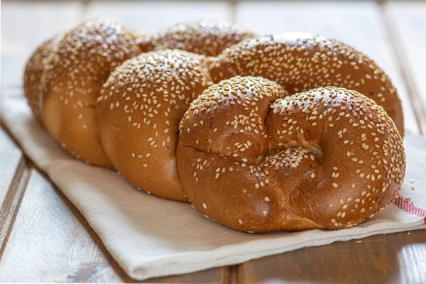 Traditional Jewish sweet Challah bread for Shabbat on a white textile on a wooden table, close up. — Stock Photo, Image