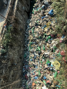 Katmandu, Nepal, 26 Nisan 2021: Yeşil çimlerin üzerindeki plastik yığını, doğal bir çevre sorunu, doğa kirliliği plastik bozulması, doğal çevrenin korunması değildir.